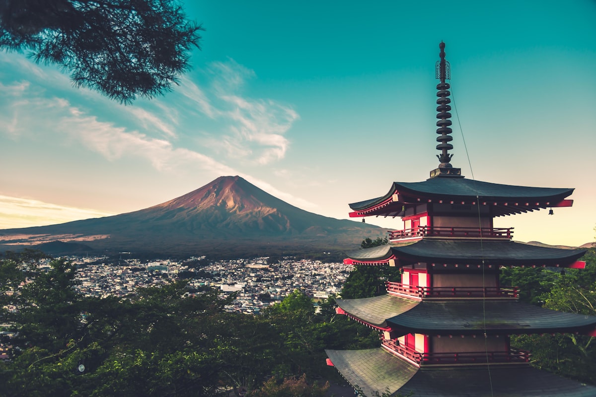 Pemandangan ikonik Gunung Fuji dengan puncak bersalju dan Pagoda Chureito di latar depan saat musim semi